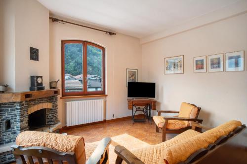 a living room with a fireplace and a tv at Casa Lilli in Pieve di Teco
