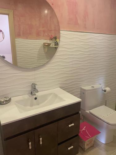 a bathroom with a sink and a mirror and a toilet at Hosteria Las Fuentes in Rubayo