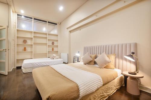 une chambre avec deux lits et une grande fenêtre dans l'établissement Magnifique Appartement au Cœur du Marais, à Paris