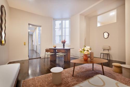 un salon avec une table et des chaises dans l'établissement Magnifique Appartement au Cœur du Marais, à Paris