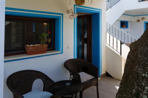 a porch with two chairs and a table and a window at B&B Tiscali in Dorgali