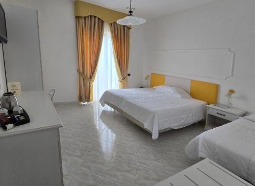 a bedroom with two beds and a large window at Hotel Il Nido Sorrento in Sorrento