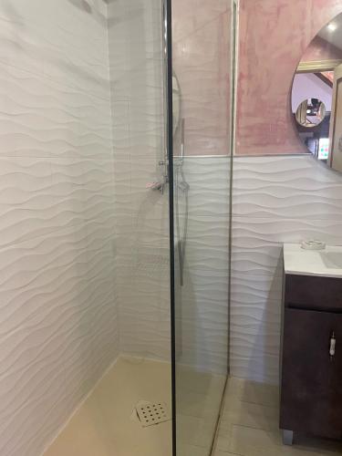 a shower with a glass door in a bathroom at Hosteria Las Fuentes in Rubayo