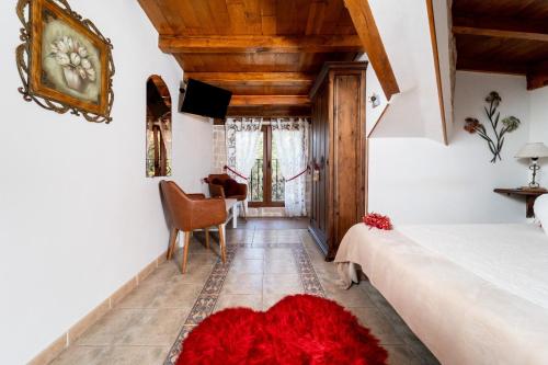 a bedroom with a bed and a red rug on the floor at Hosteria Las Fuentes in Rubayo