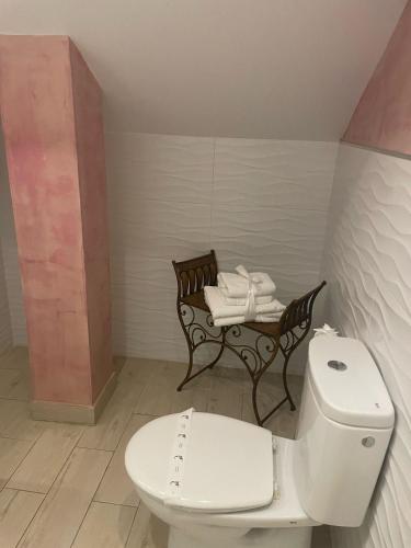 a bathroom with a toilet and a table with towels at Hosteria Las Fuentes in Rubayo