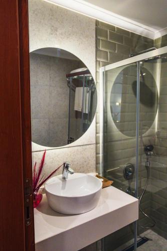 a bathroom with a white sink and a mirror at Leila Cunda Hotel in Ayvalık
