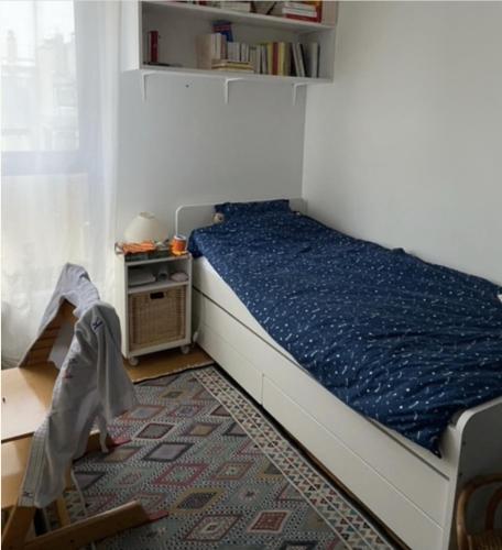 une petite chambre avec un lit avec une couette bleue dans l'établissement Couronnes 2 bis - CI - Apartment 55m2 Paris Couronnes with balcony, à Paris