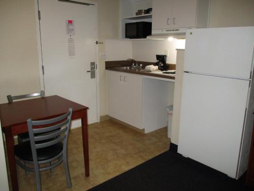 a small kitchen with a table and a refrigerator at Studio 6-Richmond, VA - I-64 West in Richmond