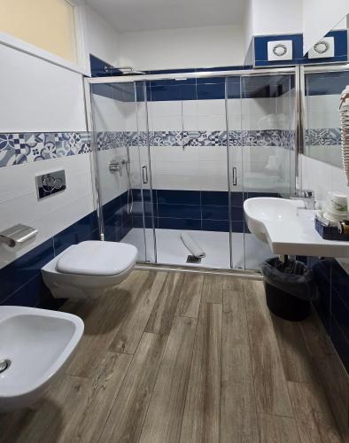 a bathroom with two sinks and a toilet and a shower at Hotel Il Nido Sorrento in Sorrento