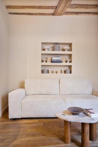 un salon avec un canapé blanc et une table dans l'établissement Appartement lumineux Marais 2 chambres, à Paris