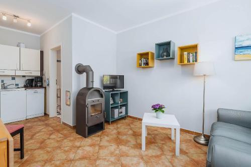 a kitchen and a living room with a stove at Kuddels Fischerhus 2 in Börgerende-Rethwisch