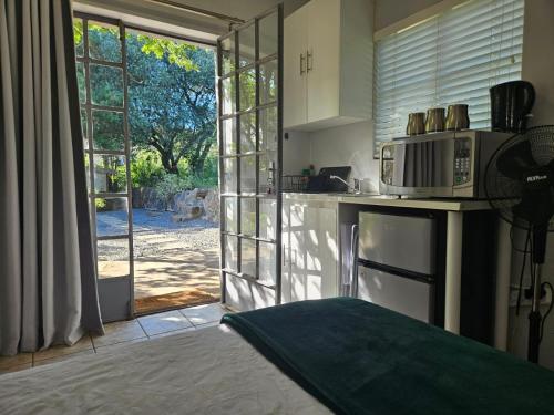 a kitchen with a microwave and a door to a yard at Peace of Nature in Bloemfontein
