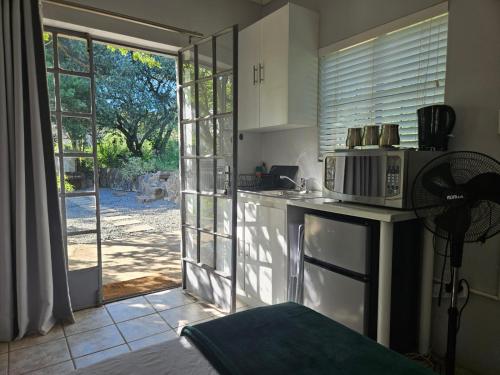 a kitchen with a microwave on a counter next to a door at Peace of Nature in Bloemfontein