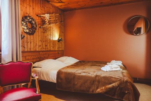 a bedroom with a bed and a red chair at Le Schallern - Accès à pieds depuis le Gaschney in Muhlbach-sur-Munster