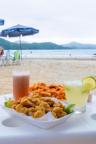 a plate of food on a table at the beach at Mar e Praia Hotel in Ubatuba