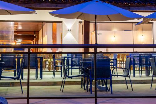 a table with blue chairs and an umbrella at Mar e Praia Hotel in Ubatuba