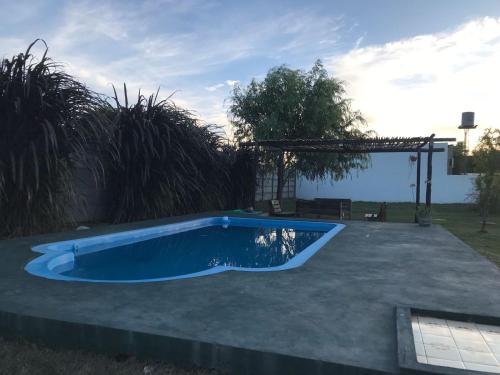 una pequeña piscina en un patio con pérgola en El Cardo, en General Belgrano
