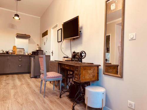 Cette chambre dispose d'un bureau, d'une télévision et d'un miroir. dans l'établissement Le Tailleur, centre historique, fibre, climatisation, ESS, rez-de-chaussée, BedinShop, à Romans-sur-Isère