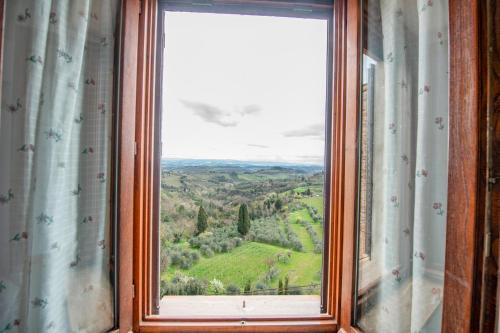 a window with a view of a green field at Bellavista free parking city center in San Gimignano