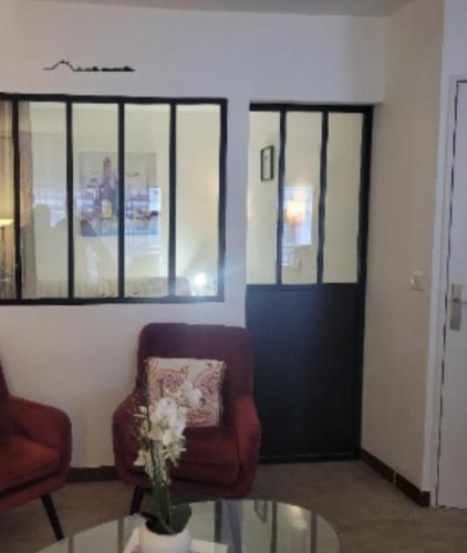 un salon avec une chaise et une table en verre dans l'établissement Centre Cannes Petit Juas, à Cannes