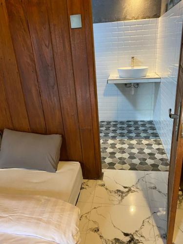 a bathroom with a bed and a sink at The Alam Bungalow & Restaurant in Tetebatu