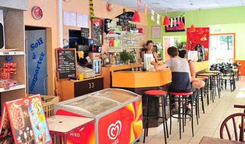 2 personnes assises au comptoir d'un restaurant dans l'établissement BONNES VACANCES sur le CAMPING LE CLOS DES PINS, à Saint-Hilaire-de-Riez