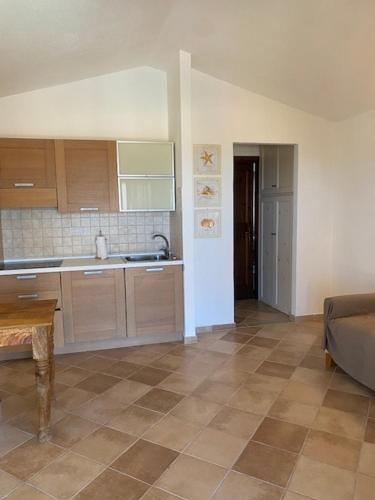 a kitchen with a couch and a table in a room at La Turritta in Badesi