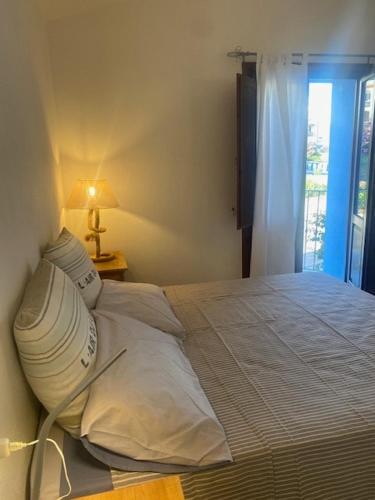 a white bed in a bedroom with a window at La Turritta in Badesi