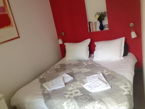 a bedroom with a bed with two pillows on it at Villa Schiller, 2 studios côté jardin - quartier Orangerie in Strasbourg
