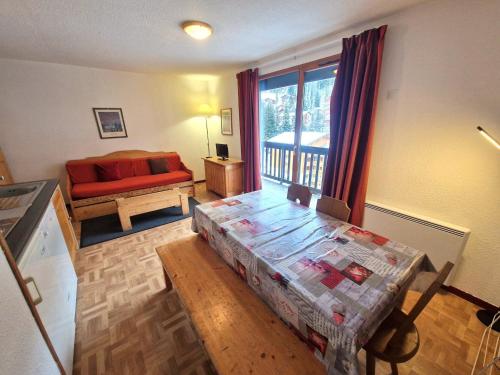 un salon avec une table et un canapé rouge dans l'établissement Appartement 2 pièces + cabine, 6 pers centre station Valfréjus avec balcon - FR-1-265-240, à Valfréjus