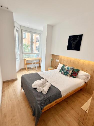 a bedroom with a large bed with towels on it at Apartamento Vive Zaragoza in Zaragoza