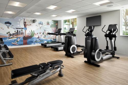 a gym with tread machines and a wall mural at Residence Inn by Marriott Miami Beach Surfside in Miami Beach