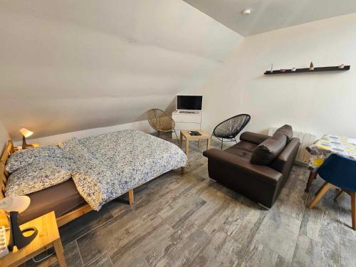 a bedroom with a bed and a couch at Studios du Cèdre in Cuvilly