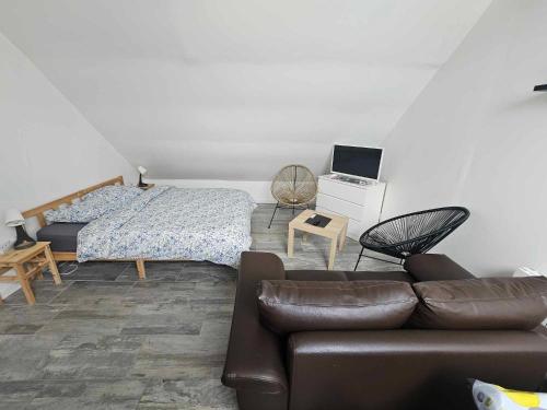 a living room with a couch and a bed at Studios du Cèdre in Cuvilly