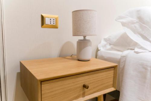 a lamp on a night stand next to a bed at Antica Loggia in Vibo Valentia