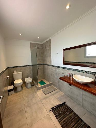 a bathroom with a toilet and a sink and a mirror at Hotel Boutique El Eden in Ranchos