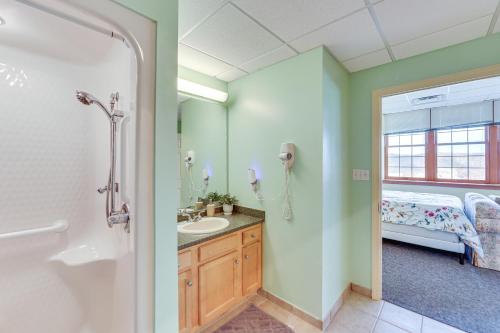 a bathroom with a shower and a sink and a bed at 1 Mi to Allegheny River New Kensington Studio! in New Kensington