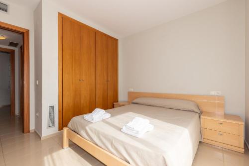 Un dormitorio con una cama con dos toallas encima. en Rentalmar Residencial La Cala, en Miami Platja