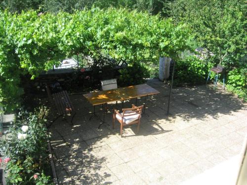 une table et des chaises assises sous une tonnelle dans un jardin dans l'établissement maison familiale en montagne près d'Ax les thermes, à Caussou