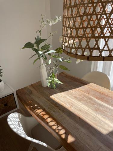 a wooden table with a vase of flowers on it at Studio Den Burg in Den Burg