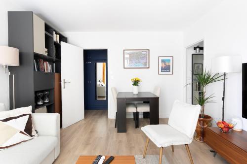 un salon avec une table et des chaises blanches dans l'établissement Auguste Laurent - KP - Charming apartment with balcony 4 pers Paris 11, à Paris