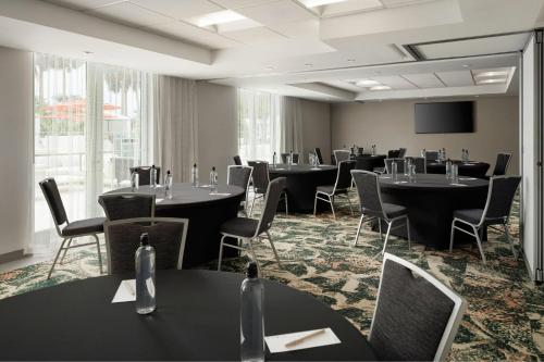 a conference room with tables and chairs and a flat screen tv at Residence Inn by Marriott Miami Beach Surfside in Miami Beach