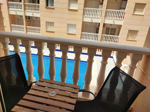 balcone con tavolo e computer portatile su sedia di Comfortable apartment with 2 bedrooms and Pool a Torrevieja