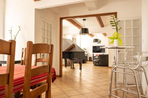 un salon avec une table et un piano dans l'établissement La maison du bonheur, à Pélissanne