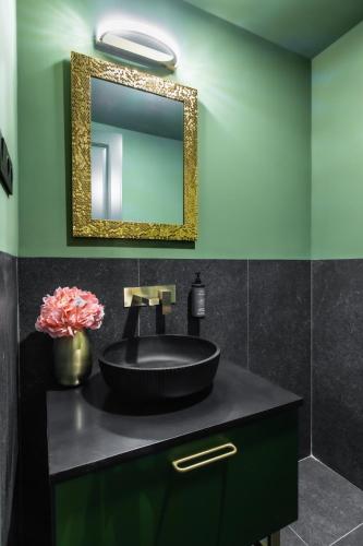 a bathroom with a black sink and a mirror at Erdei Szelencék in Sukoró