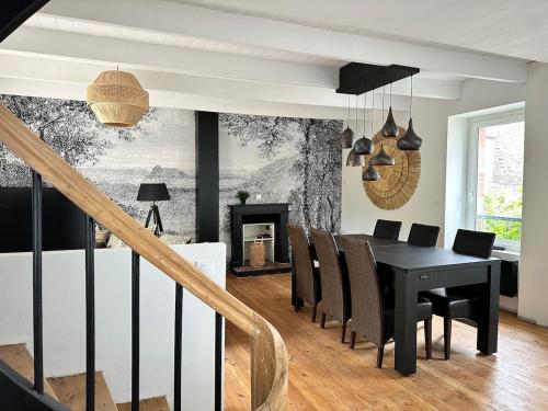 une salle à manger avec une table et des chaises noires dans l'établissement L'atmosphère, à Plérin