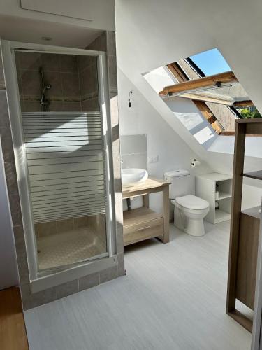 une salle de bain avec une douche en verre et des toilettes dans l'établissement L'atmosphère, à Plérin