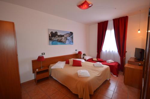モンテメラノにある8380 camere Mastroのベッドとテレビが備わるホテルルームです。