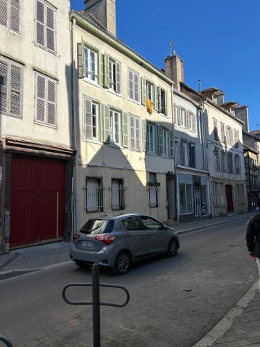 une voiture garée devant un bâtiment dans une rue dans l'établissement Le Jaillant - Wifi - Centre Ville historique - Proche Gare, à Troyes