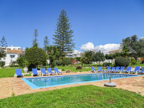 - une piscine avec des chaises longues bleues à côté d'une cour dans l'établissement Quinta de Lagos, à Lagos